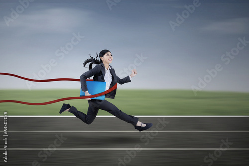 Businesswoman winning a business race © Creativa Images