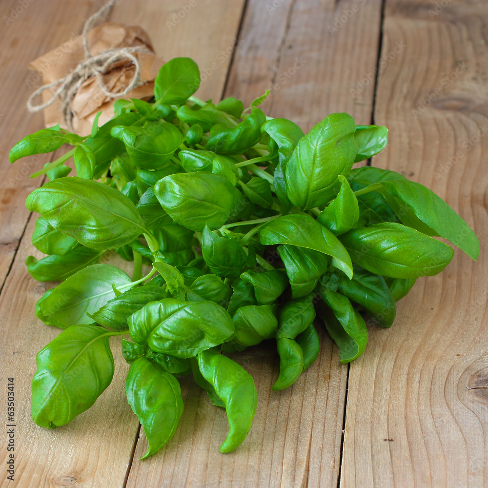 Fresh basil leaves on wooden table Fresh basil leaves on wooden table