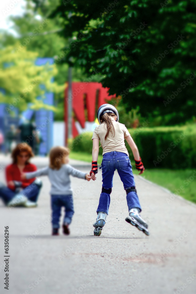 Young girl skating with little syster