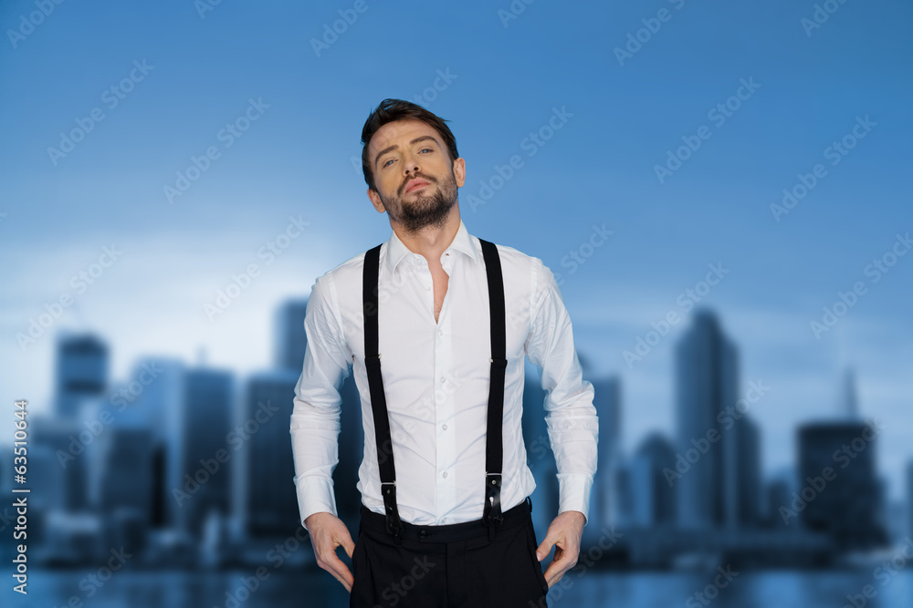handsome man on blue wearing white shirt and braces handsome man on blue wearing white shirt and braces