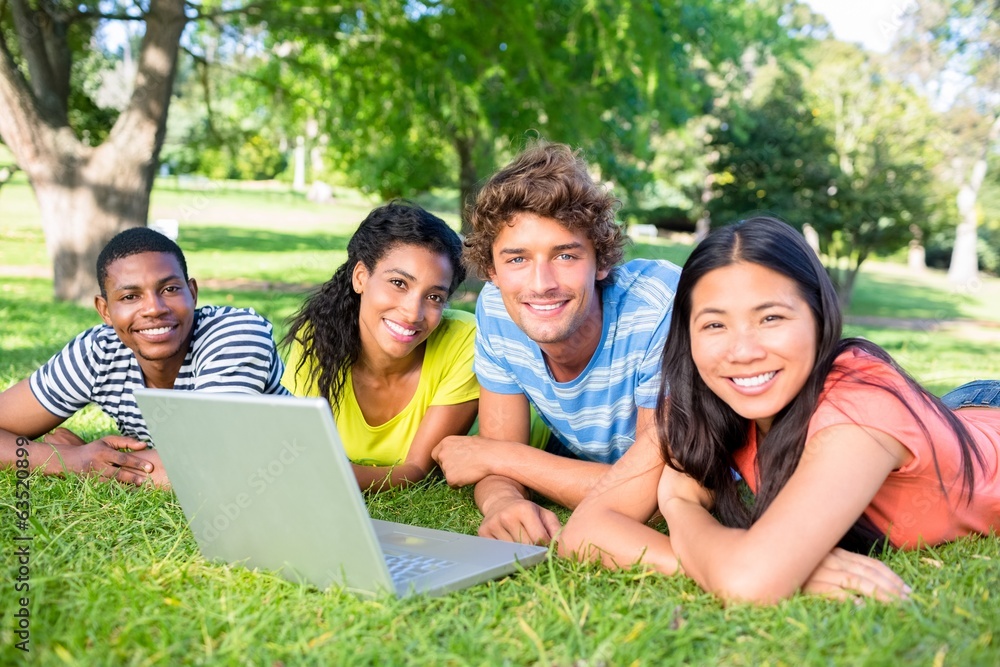 Students with laptop lying on campus Students with laptop lying on campus