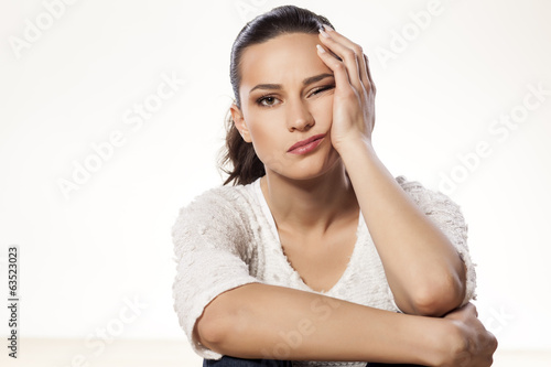 young woman full of boredom leaned her head on her hand photo