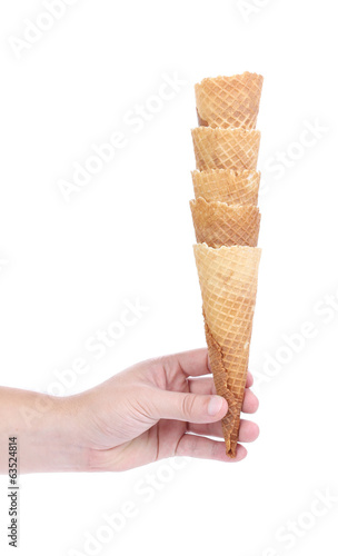 Hand holds stake of wafer cup for ice-cream.