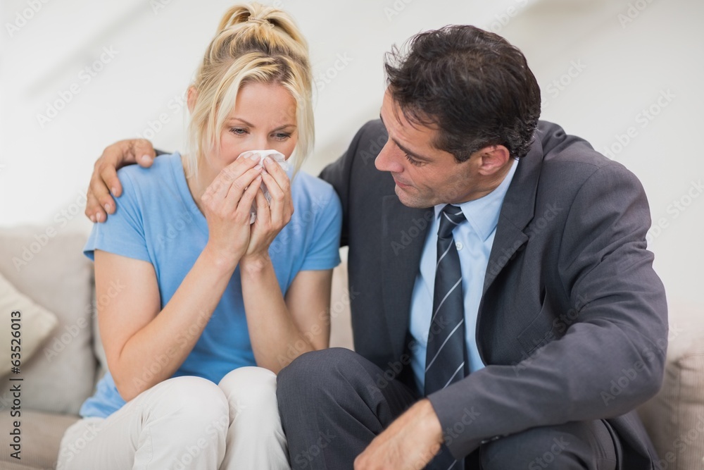 Well dresses man consoling a woman in living room Well dresses man consoling a woman in living room