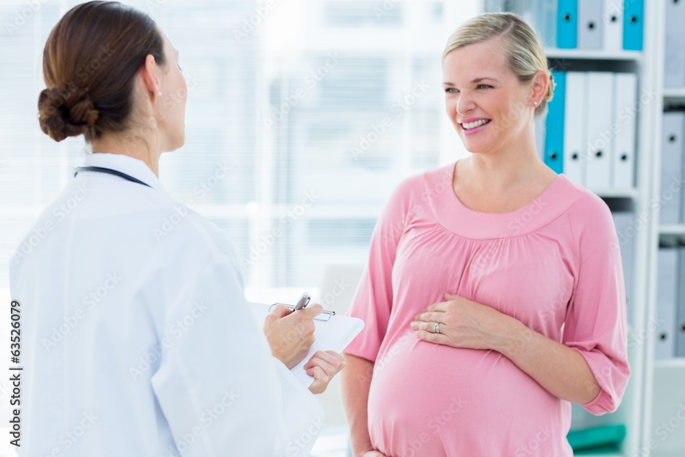 Pregnant woman discussing with female doctor Pregnant woman discussing with female doctor