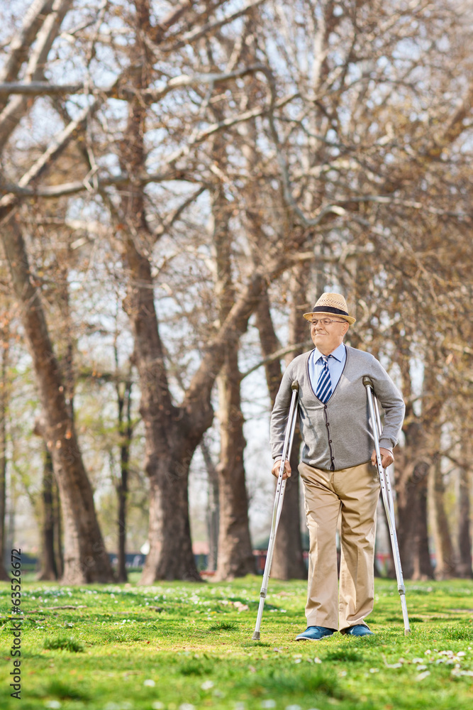 Elderly gentleman walking with crutches outdoors Elderly gentleman walking with crutches outdoors
