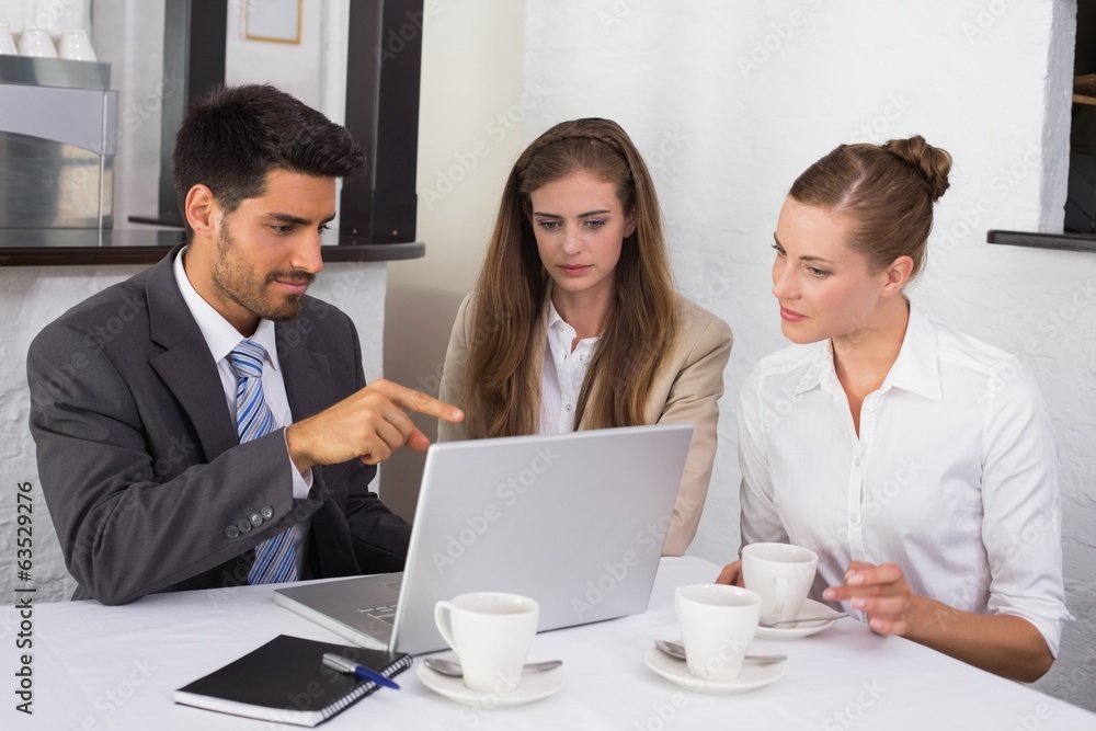 Business people using laptop together at office desk Business people using laptop together at office desk