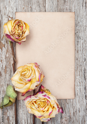 Dry roses and paper on the old wood