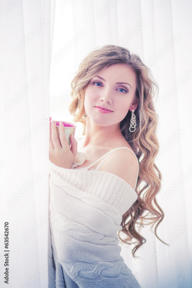 The girl in a white jacket holding the Cup in the Studio. The girl in a white jacket holding the Cup in the Studio.