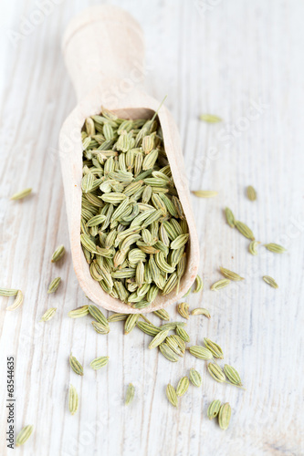 fennel seed in a wooden scoop on table