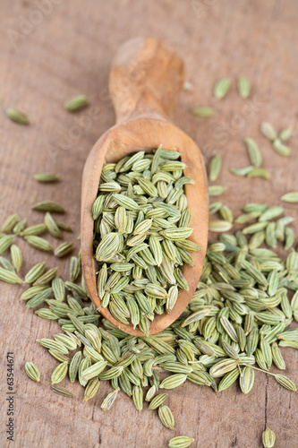 fennel seed in a wooden scoop on table