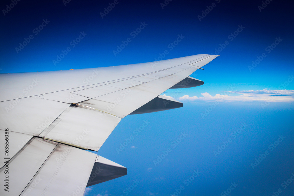 Wing of the plane on blue sky background