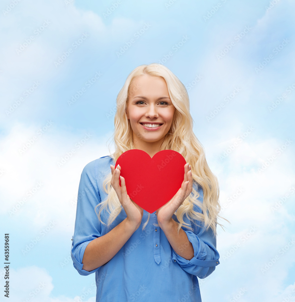 smiling woman with red heart - obrazy, fototapety, plakaty 