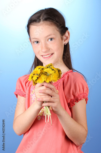 Portrait of beautiful little girl with dandelions