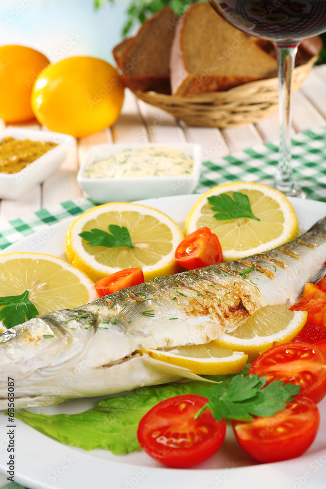 Delicious grilled fish on plate on table close-up Delicious grilled fish on plate on table close-up