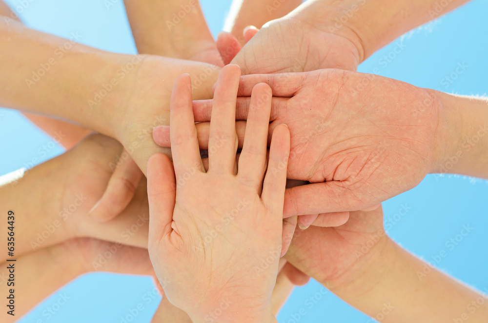 Many hands together over blue sky. Many hands together over blue sky.