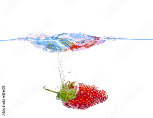 fresh strawberry dropped into water with splash