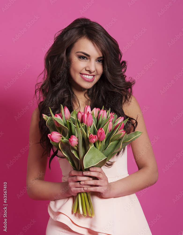 Woman in wavy hair holding spring bouquet