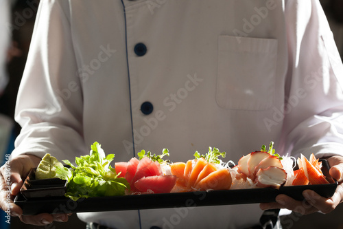 Fotografi sashimi, a chef uniform holding a dish of Japanese Sashimi