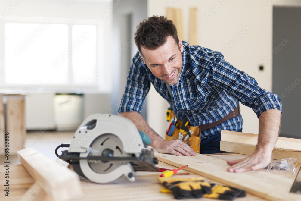 Smiling carpenter checking result of his work Smiling carpenter checking result of his work