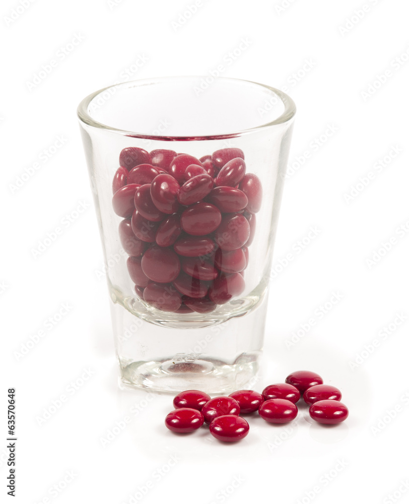 Red pills and pill bottle on white Red pills and pill bottle on white