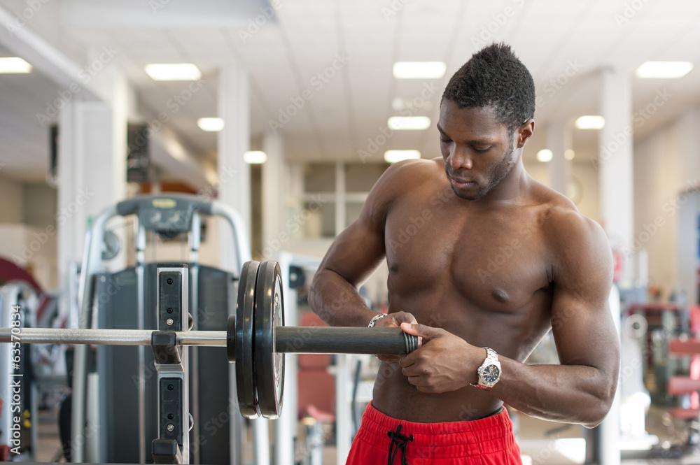 Strong black man adjusting heavy lift on bar in the gym. Strong black man adjusting heavy lift on bar in the gym.