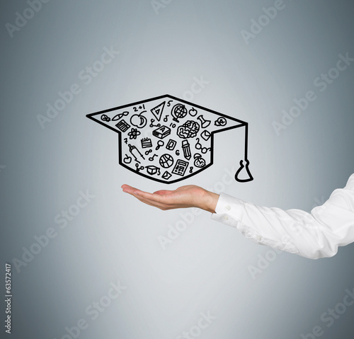 A hand holding a graduation hat photo