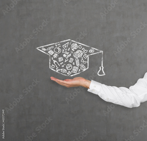 A hand holding a graduation hat