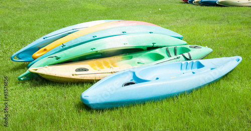 Colorful Kayaks Resting on Bright Green Grass