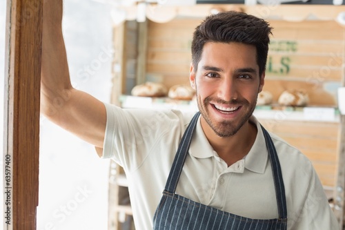 Smiling confident male barista at coffee shop