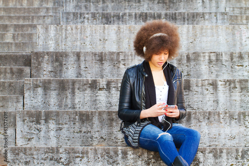 Young woman with smartphone and headphones photo