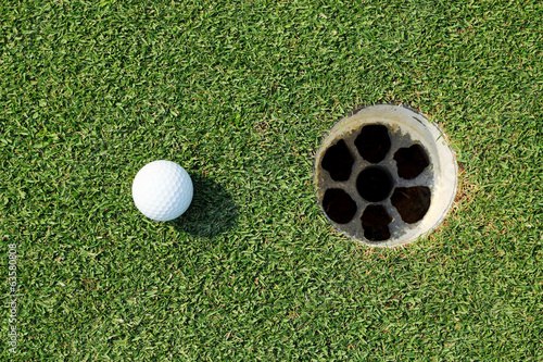 golf ball near the hole on green grass