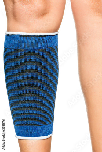 Young woman with an elastic band on her leg isolated on white