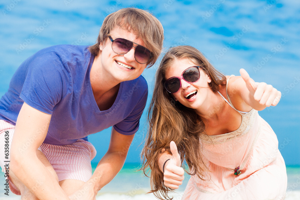 Portrait of happy young couple in sunglasses having fun on
