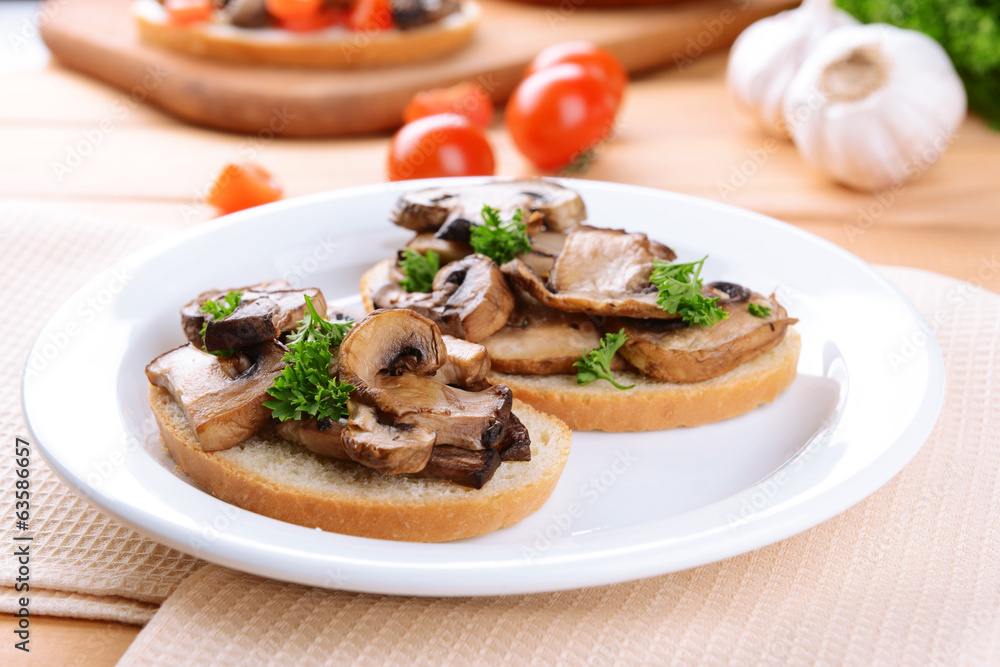 Delicious bruschetta with mushrooms on plate on table close-up