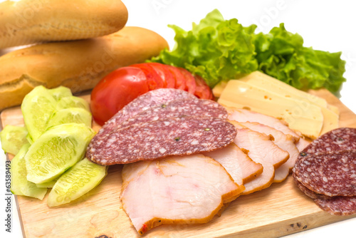 Sandwich ingredients on a wooden board against white background