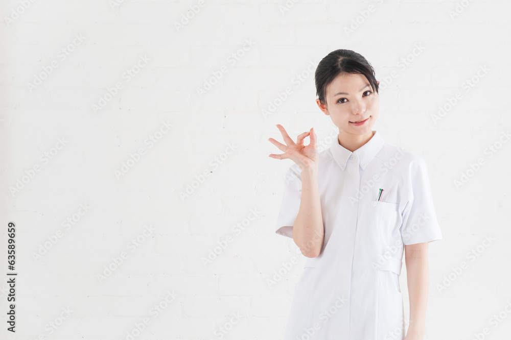 白い壁の前に立つ看護師