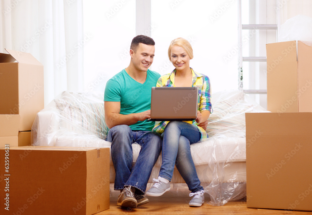 couple relaxing on sofa with laptop in new home couple relaxing on sofa with laptop in new home