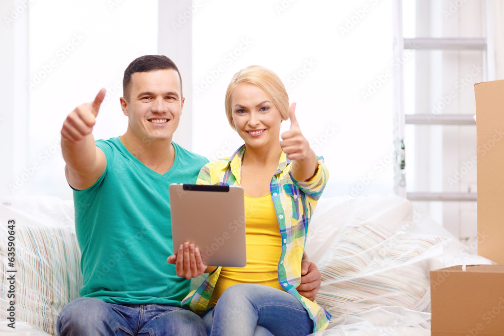 couple relaxing on sofa with tablet pc in new home couple relaxing on sofa with tablet pc in new home