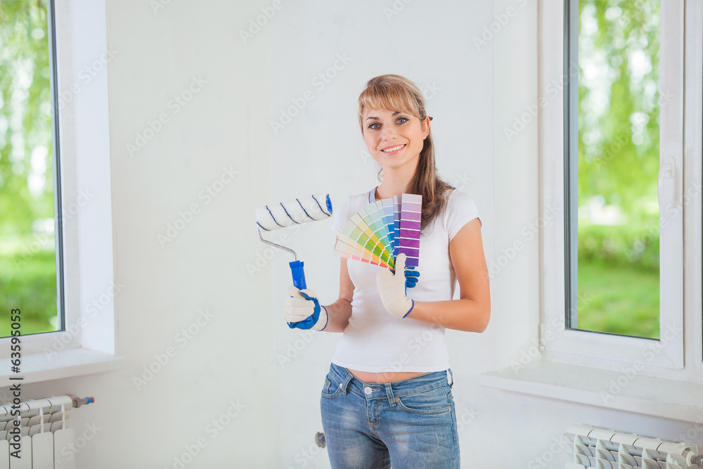 smiling female holding paintroller and color palette at home smiling female holding paintroller and color palette at home