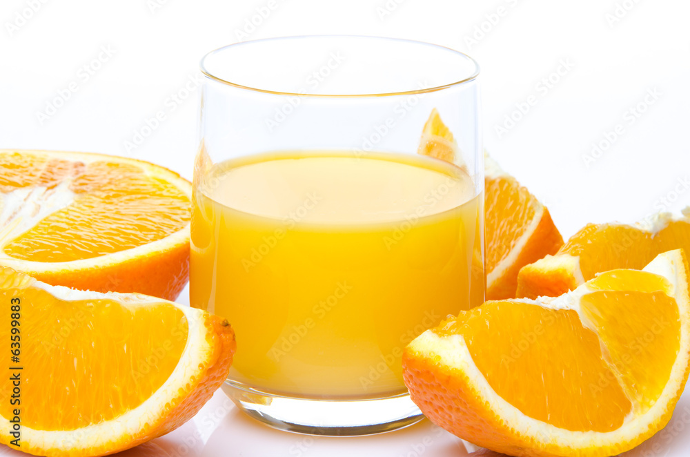 A glass of orange juice with orange quarters A glass of orange juice with orange quarters