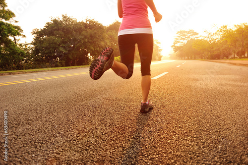 young fitness woman running at sunrise road