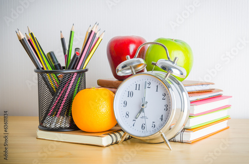 Back to school , note book , clock , pencil , apple on wood tabl