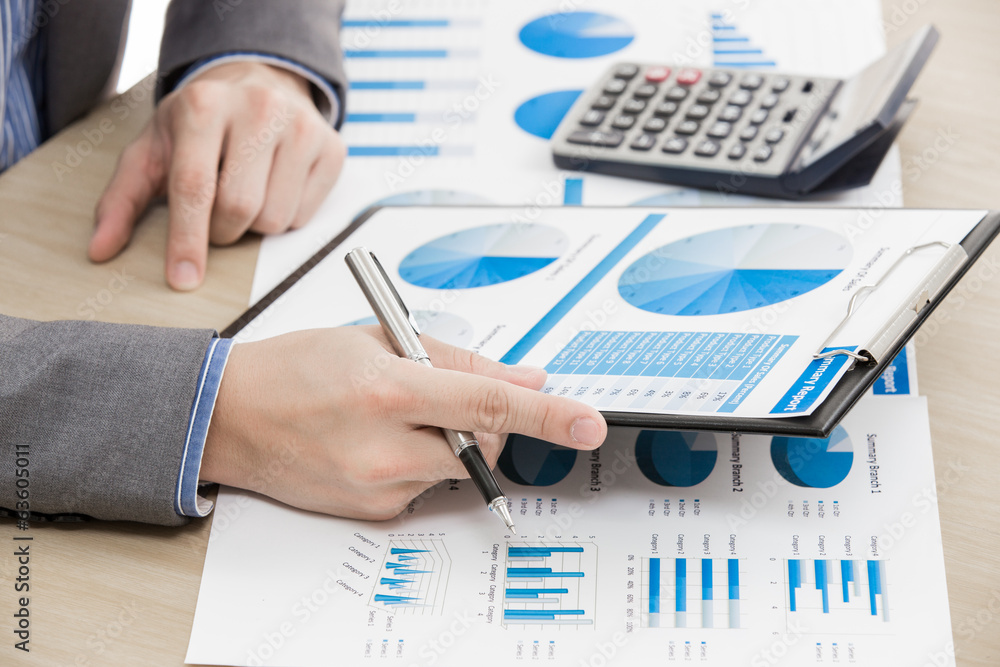 business report and man hand with pen business report and man hand with pen