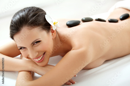 Spa Tretment. Beautiful Woman Getting Spa Hot Stones Massage