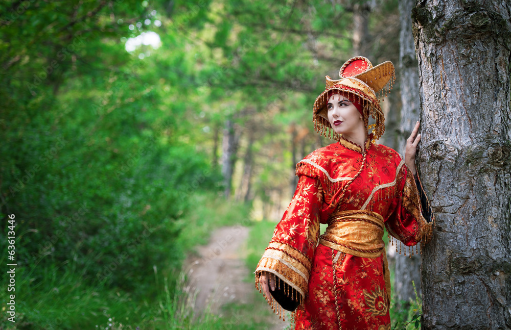 Woman in Chinese princess costume in the pine forest Woman in Chinese princess costume in the pine forest