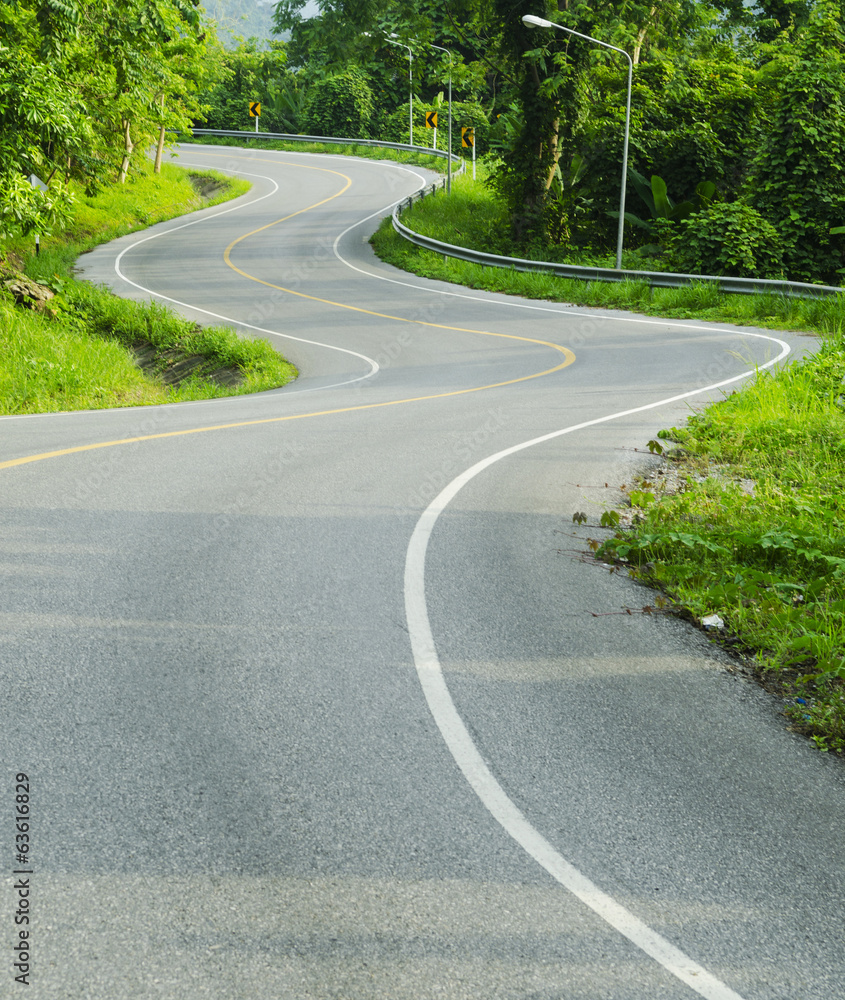 Asphalt road sharp curve along with tropical forest zigzag ahead
