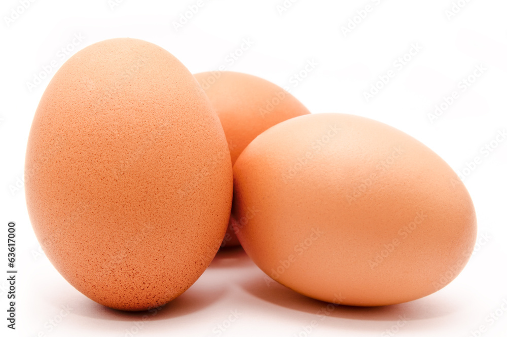 Three brown chicken eggs isolated on a white background