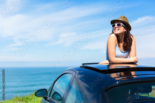 Woman on summer vacation leaning out sunroof photo