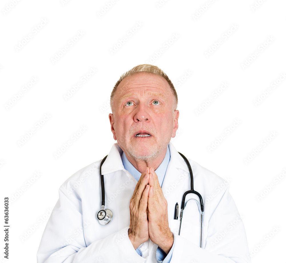 Senior male doctor praying asking for best patient outcome Senior male doctor praying asking for best patient outcome